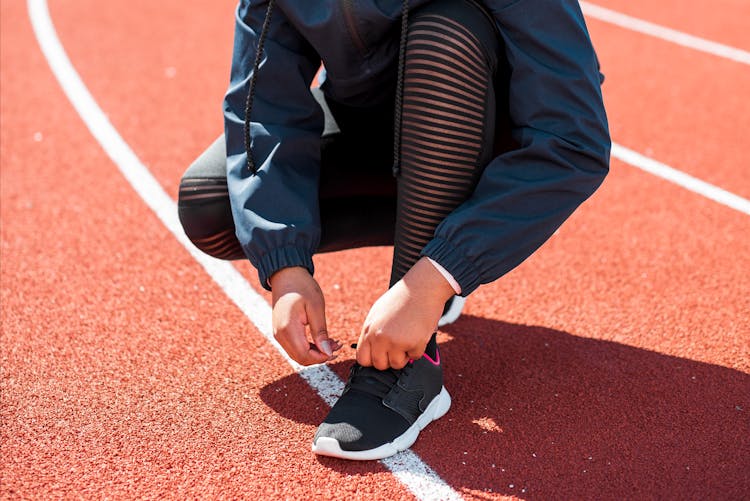 Person Tying A Shoe On A Track