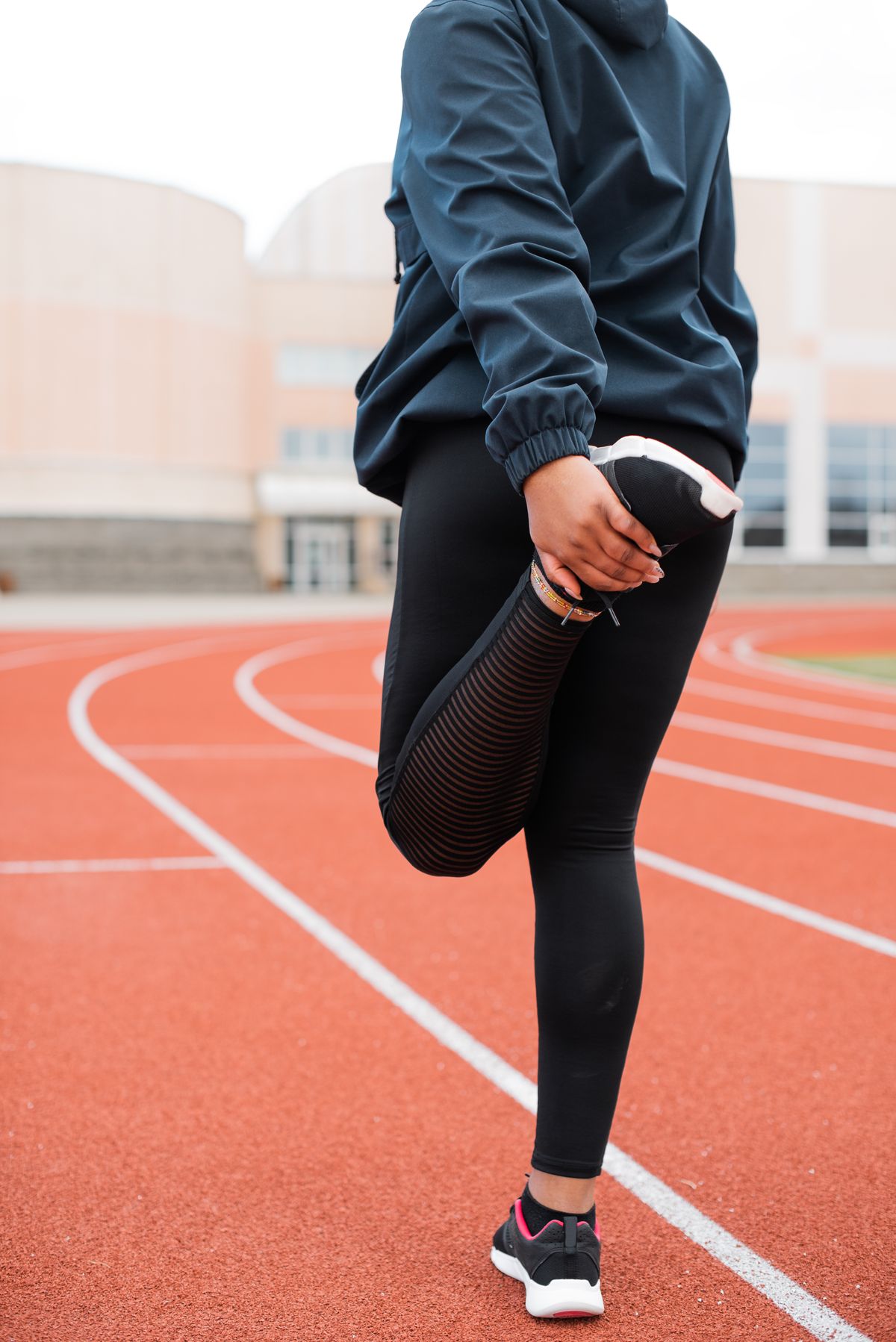 Athlete lifting a knee during a warm-up on a running track