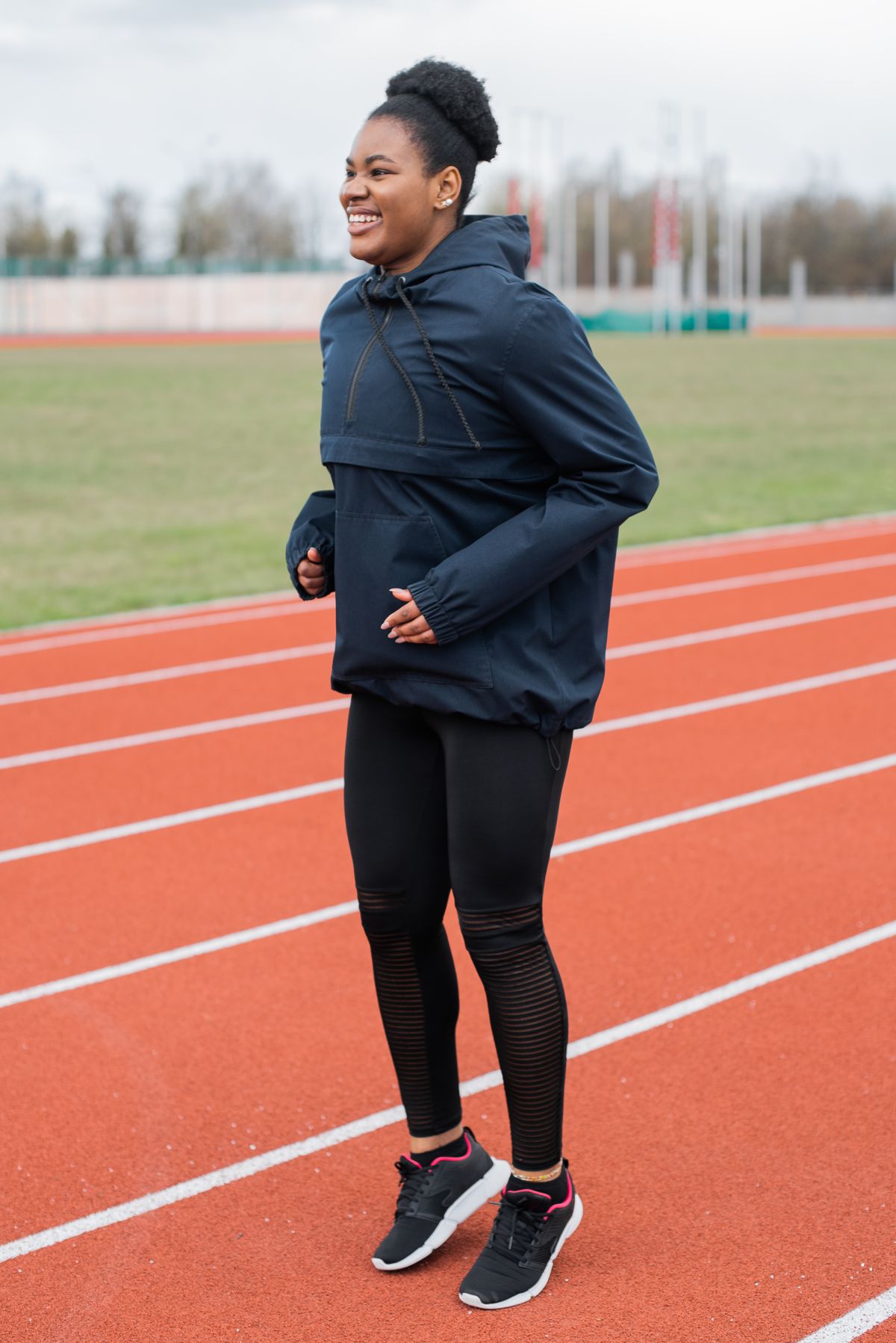 Woman in modern sportswear standing on an outdoor running track