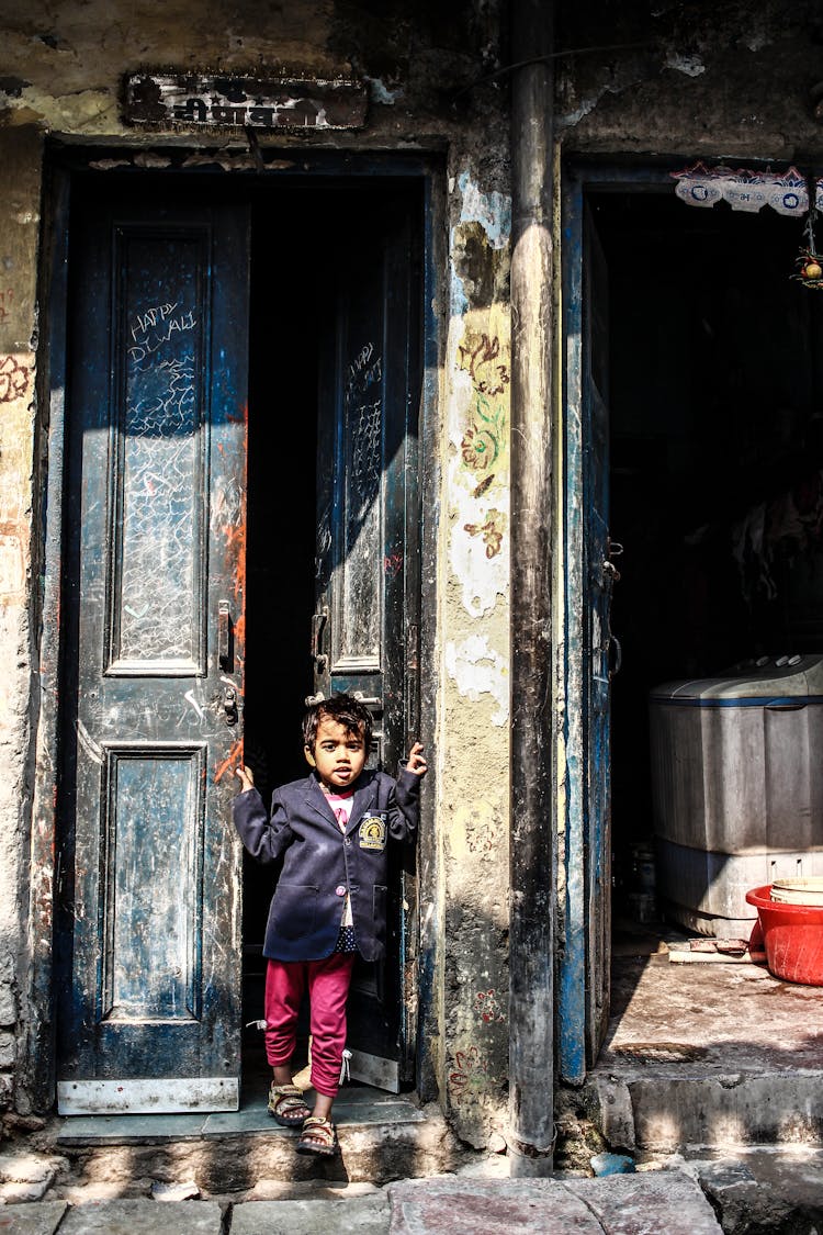 A Little Boy Standing By The Door