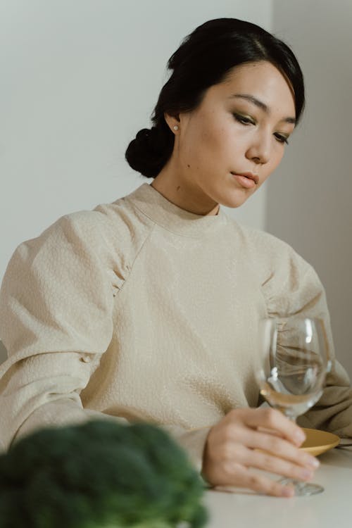 Woman with a Sad Face Holding an Empty Wine Glass