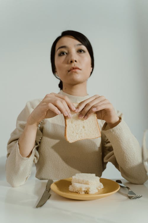 Woman With  Sad Face Holding a Slice of Bread
