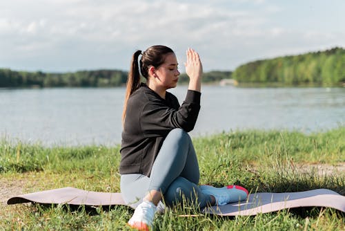Free Woman Meditating Near the Lake  Stock Photo