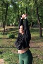 Woman in Black Long Sleeve Shirt and Black Shorts Standing on Green Grass Field