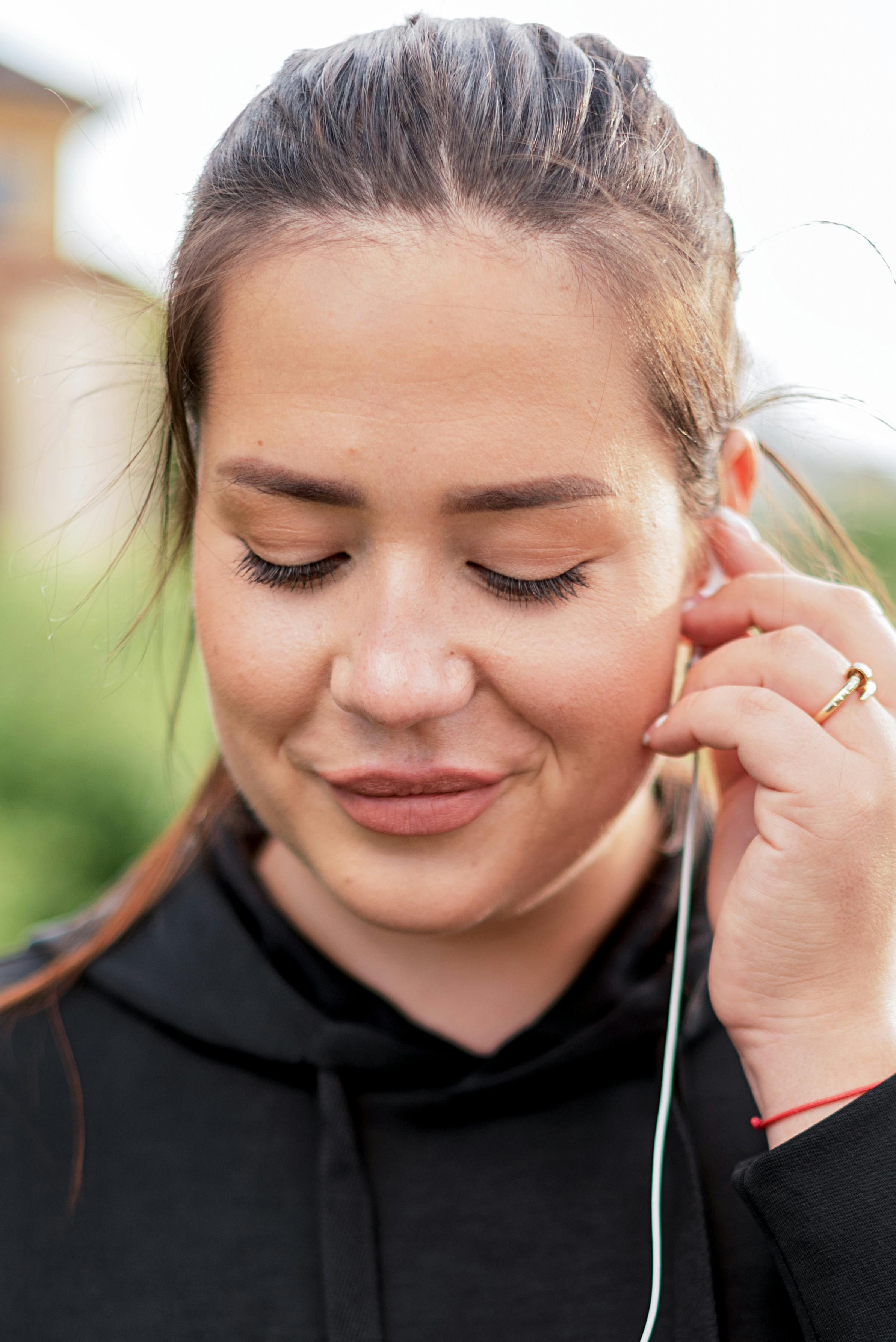 a woman putting on an earphone
