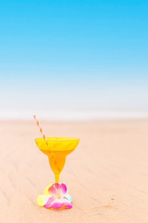 Free Yellow Cocktail Glass on the Sand Stock Photo