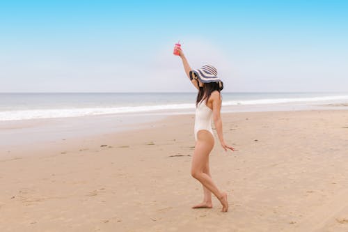 A Woman in White Swimsuit Standing on the Beach