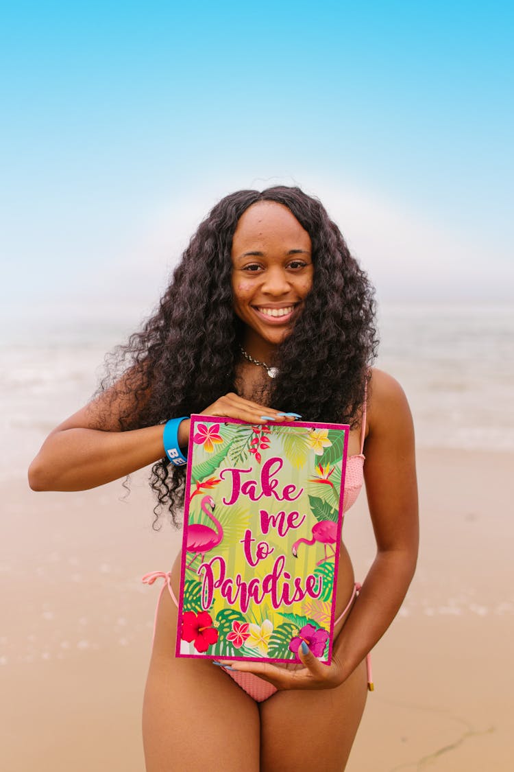 A Woman In Pink Swimsuit Holding A Poster