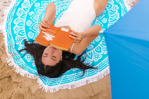 A Woman Reading a Book at the Beach