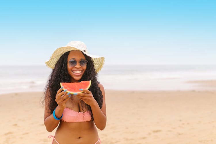 A Woman Eating Watermelon In The Beach