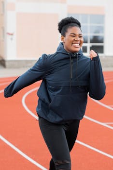African American woman enjoying a vibrant workout on an outdoor running track.
