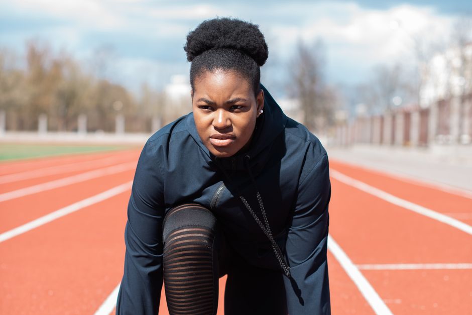 runner stretching before track race