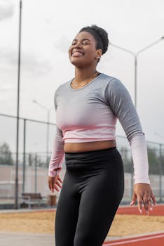 Happy woman in sportswear enjoying a refreshing outdoor workout with a smile on her face.