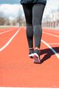 Woman in Black Leggings and Black and White Nike Sneakers Running on Track Field