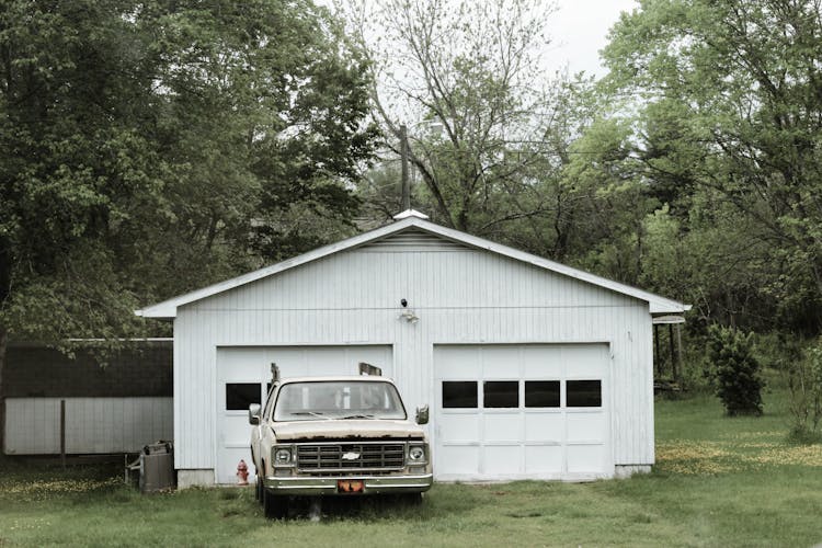 Classic White Chevrolet Pickup Truck Near White 2-door Garage Near Trees