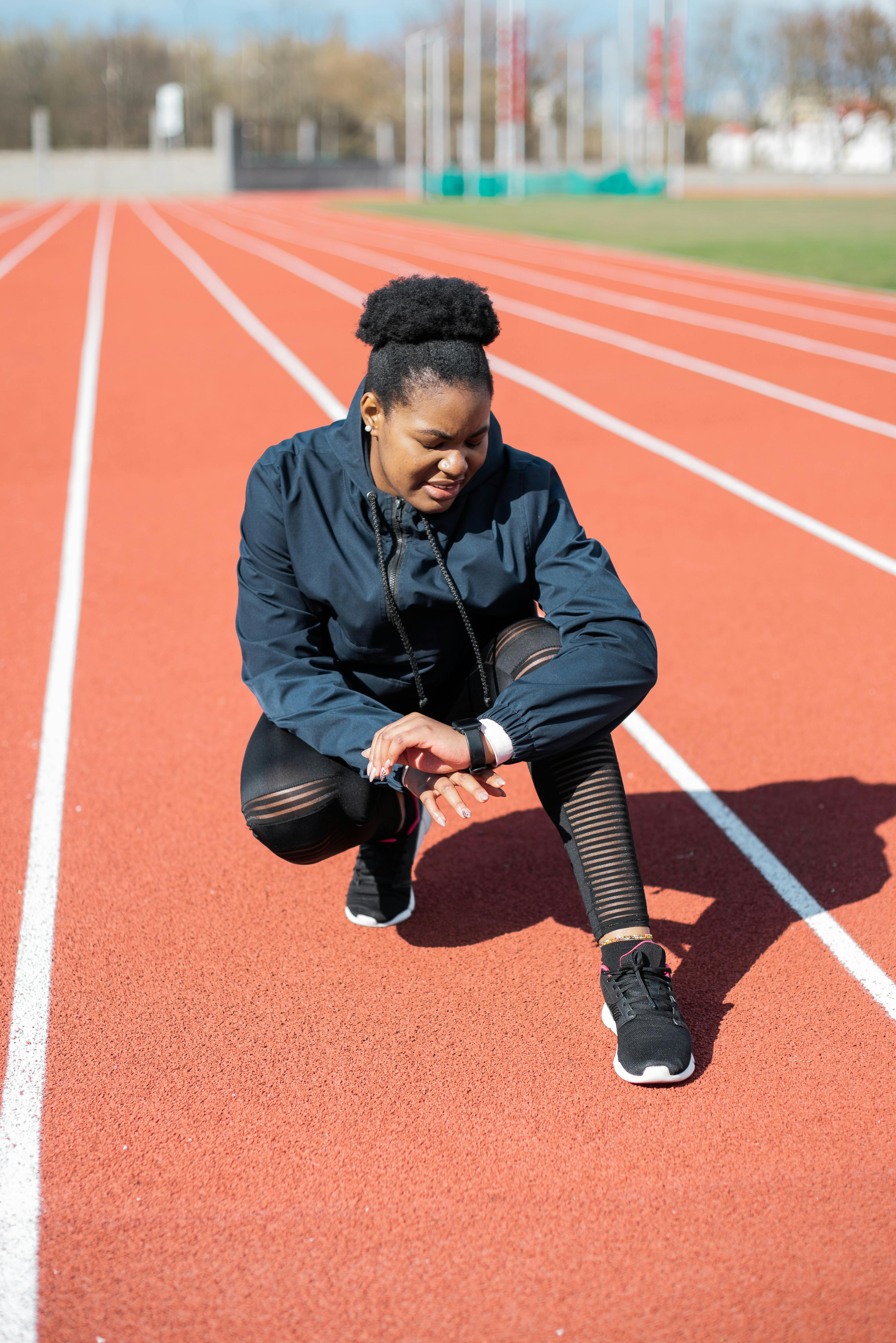 Black woman, running track and stretching in fitness workout