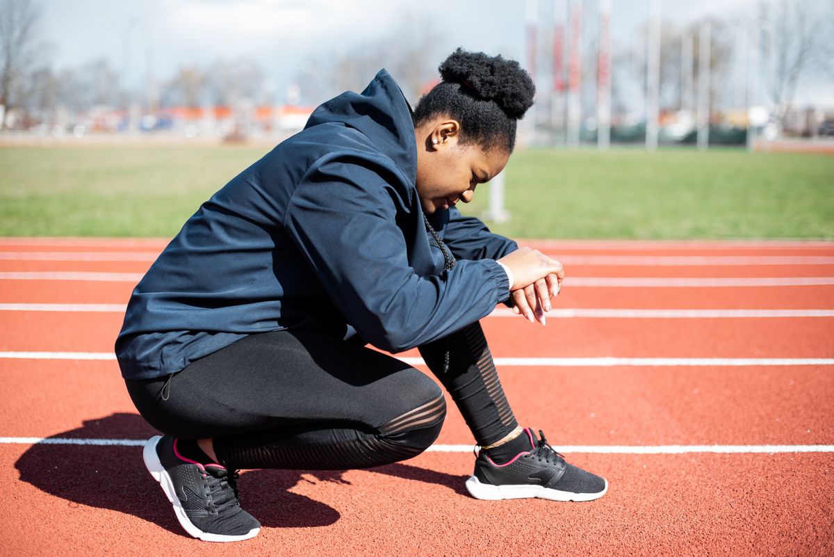 Woman in performance sportswear training on an outdoor running track