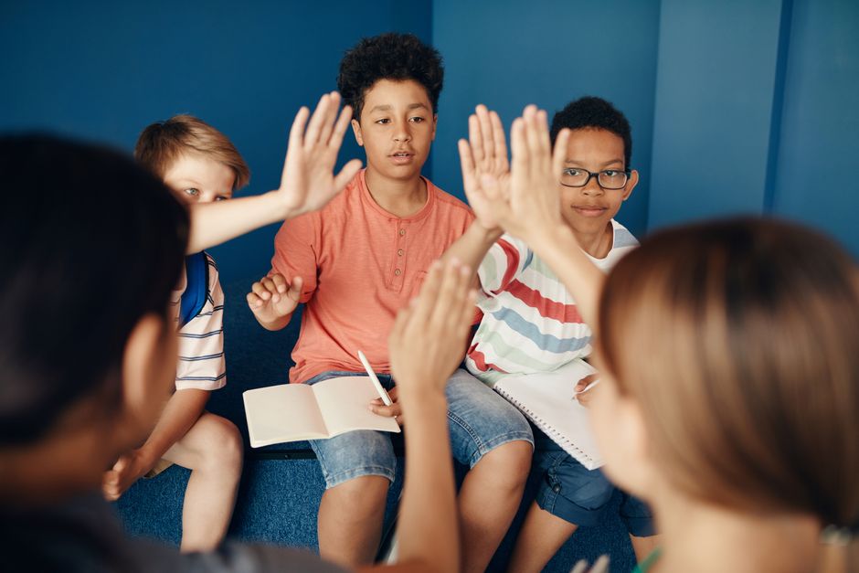 Gruppe unterschiedlicher Kinder, die im Klassenzimmer zusammenarbeiten und gemeinsam lernen.
