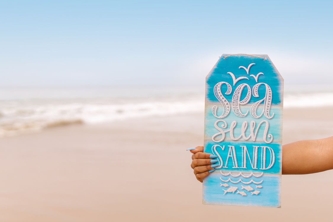 Beach Sign Hand A Person Holding a Sign on the Beach · Free Stock Photo