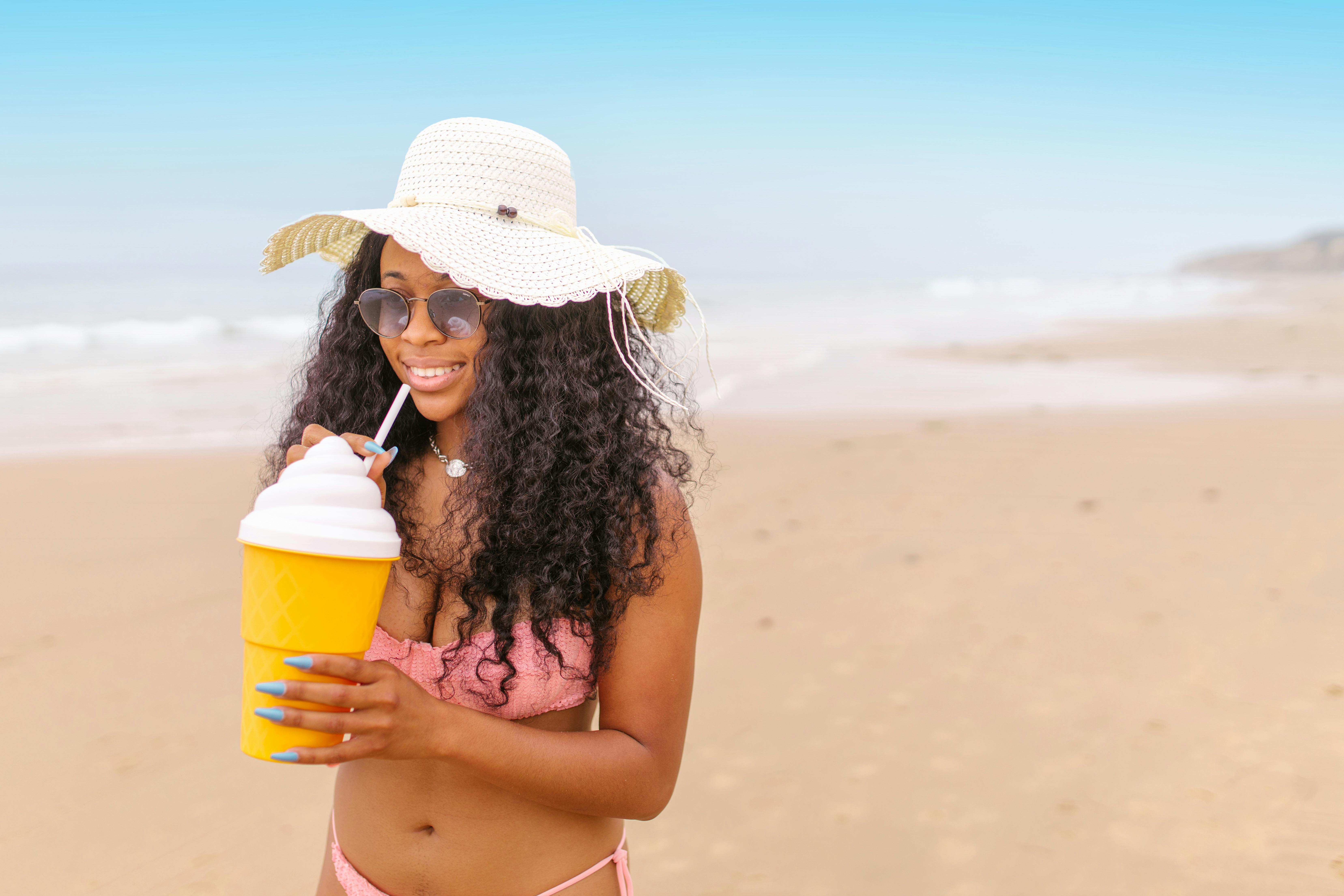 Red-haired beauty in a bikini and beach hat Stock Photo by