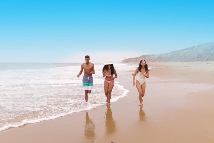 Group Of People Running On The Beach