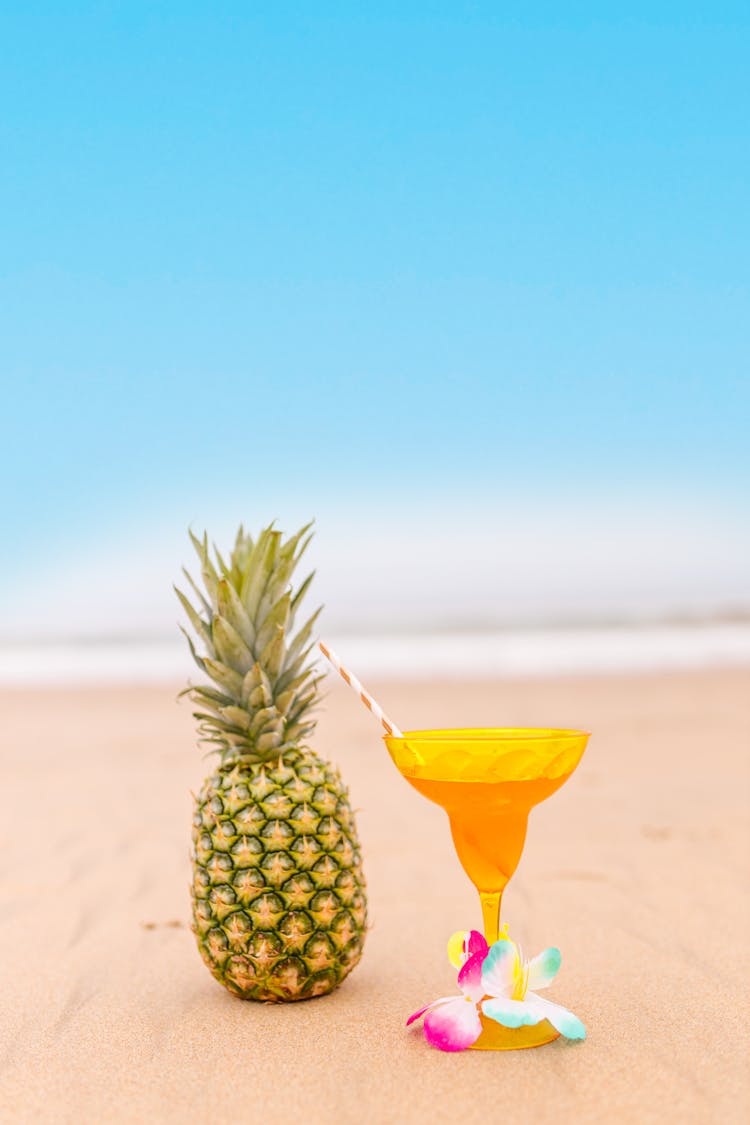 Pineapple And Cocktail Glass On The Beach