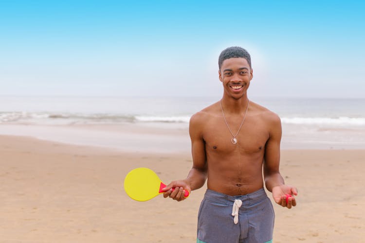 A Shirtless Man Playing Ping Pong In The Beach