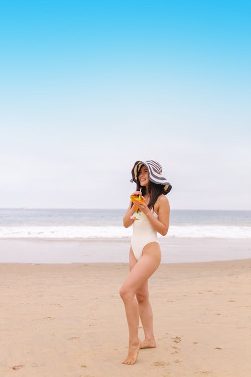 A Woman in White Swimsuit Standing on Beach