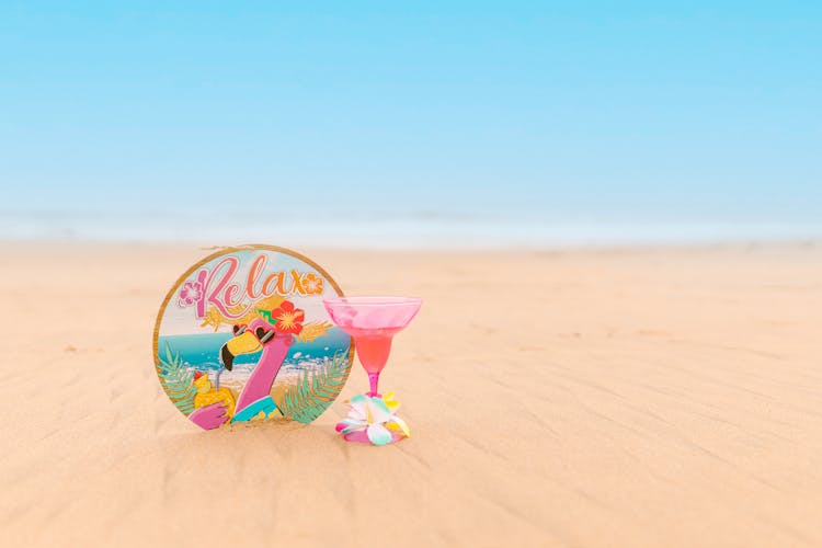 Pink Cocktail In Glass On Sand Beach