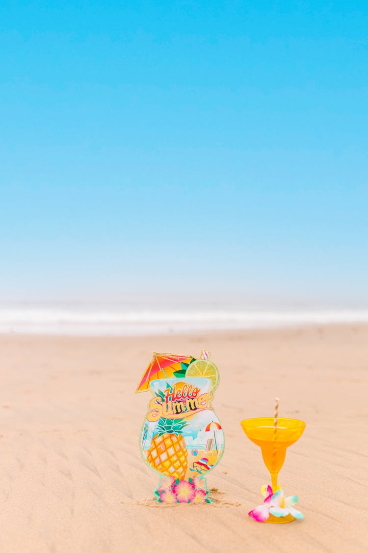 Yellow Cocktail Glass On Beach Sand