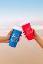 Two People Holding Red and Blue Plastic Cups