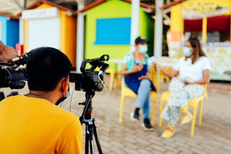 Operator Filming Interview On Camera Outdoors