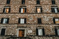 Low-angle view of an old brick façade in Perugia, Italy, showcasing traditional architecture.