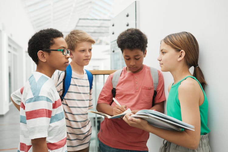 Young Students Standing At A Hallway