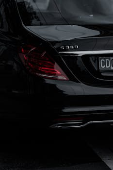 Close-up shot of the rear view of a black Mercedes S350, highlighting its elegant tail lights.