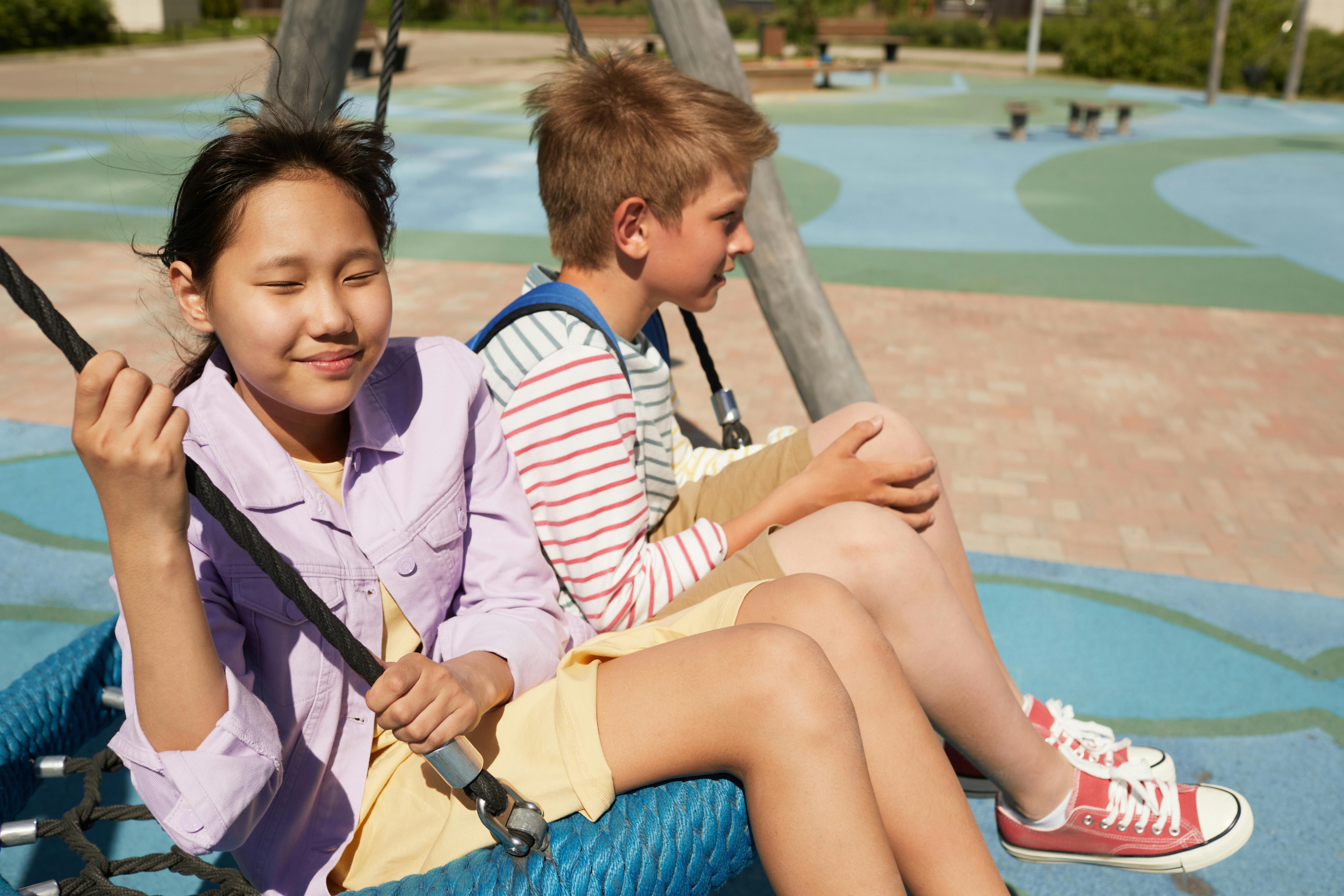 kids sitting on a swing together