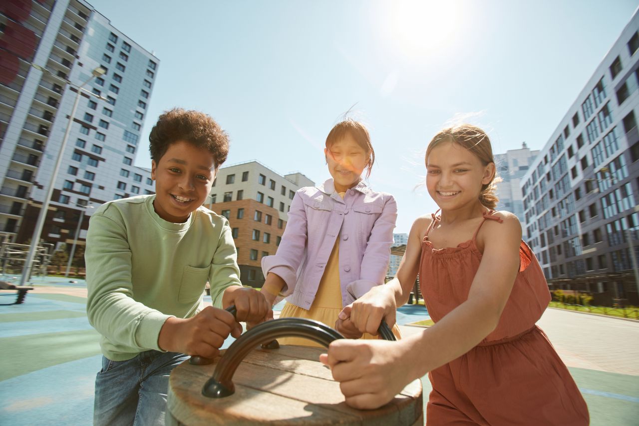 A group of diverse children playing joyfully outdoors on a sunny day.
