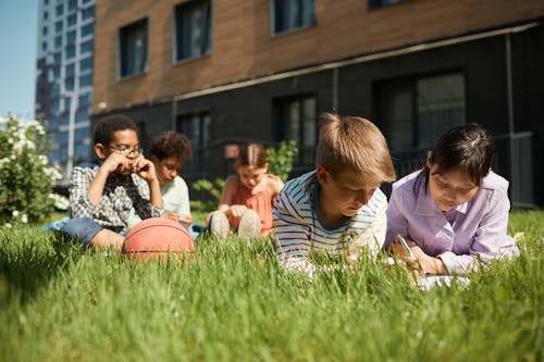 Group of Kids on a Grass Field while Studying Together