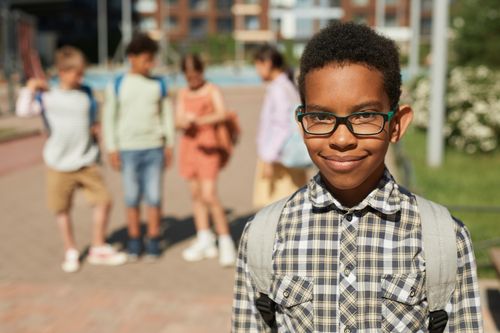 Free Diverse group of children smiling at school playground on a sunny day. Stock Photo
