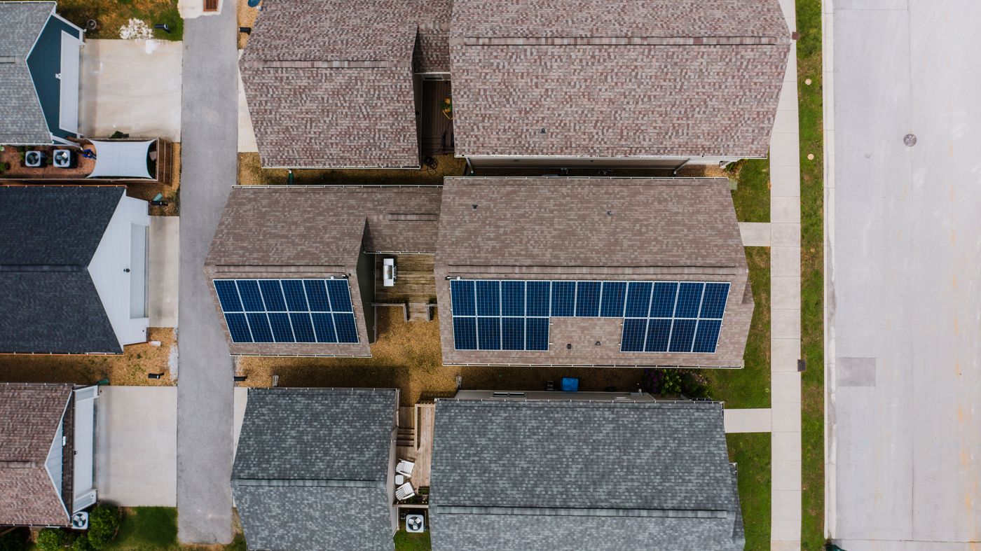 Vista aérea de viviendas con paneles solares en varias cubiertas; fotografía ilustrativa, no de una comunidad de Cataluña