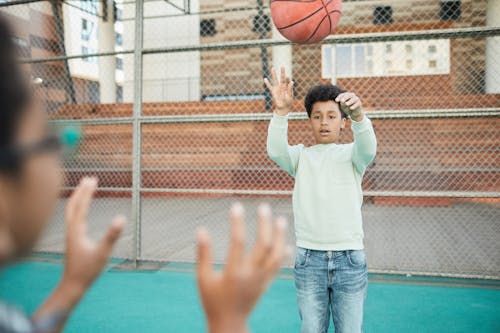 Photo of a Boy Passing a Ball
