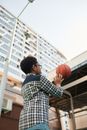 Man in Blue and White Plaid Dress Shirt Holding Basketball