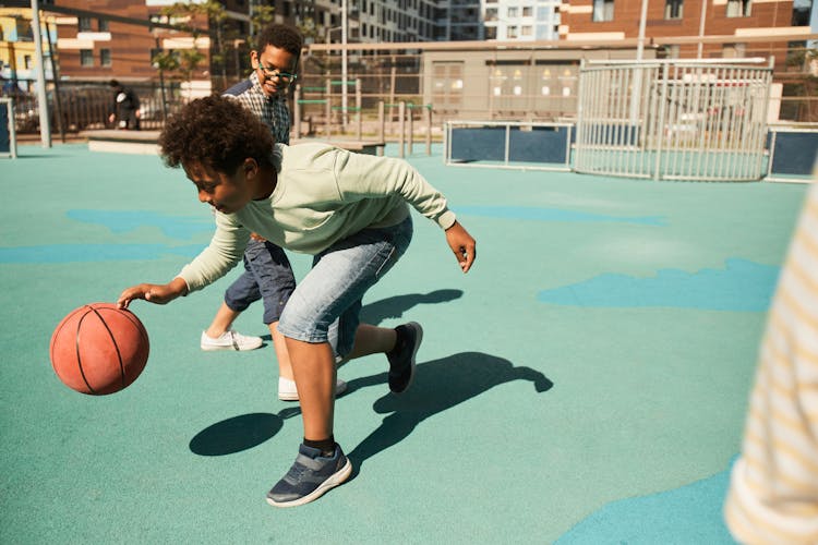 Young Boys Playing Basketball On The Court