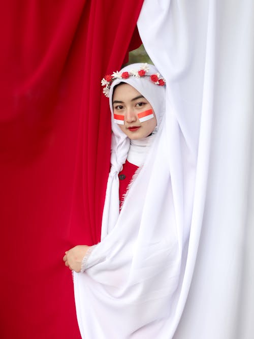 Young Woman with Flags of Indonesia Painted on Her Cheeks 