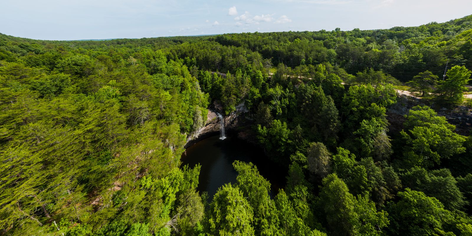 A waterfall surrounded by dense green forest near the Midland Trail