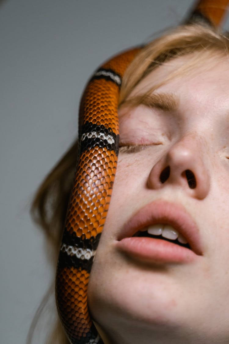 Close-Up Photo Of A Woman Overcoming Her Fear Of Snakes