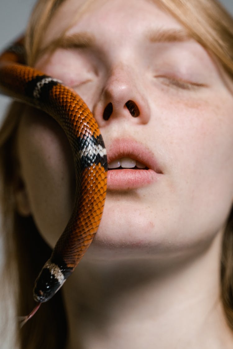 Close-Up Photo Of A Woman Overcoming Her Fear Of Snakes