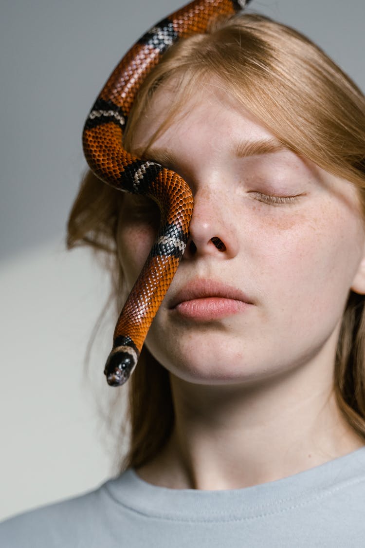 Close-Up Photo Of A Woman Overcoming Her Fear Of Snakes