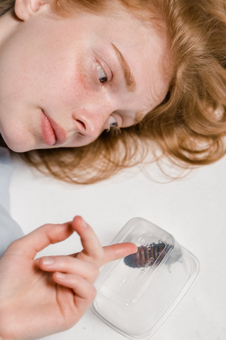 Close-Up Photo Of A Fearful Woman Lying Down While Overcoming Her Fear Of Cockroaches