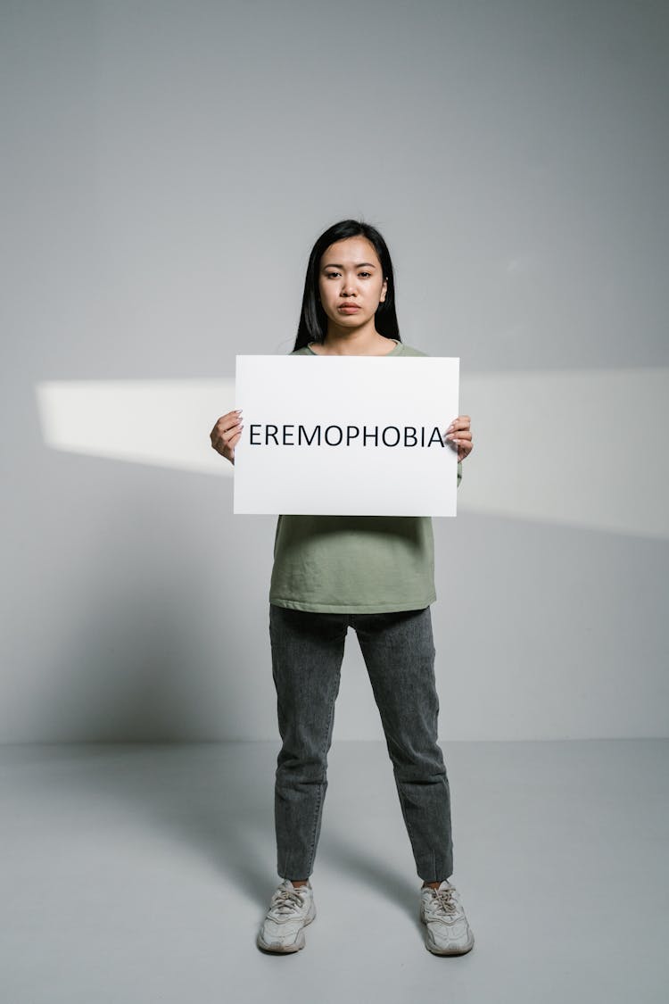 A Woman Holding A Sign Of Eremophobia